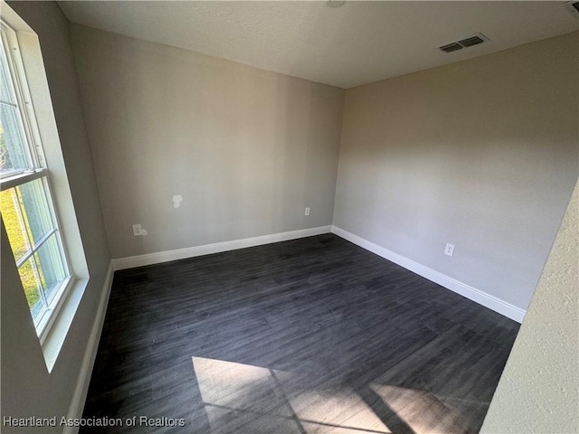 empty room with dark wood-type flooring