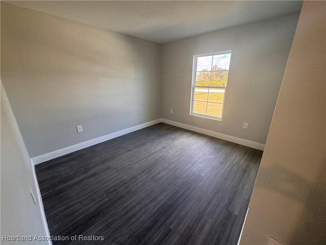 unfurnished room with dark hardwood / wood-style flooring