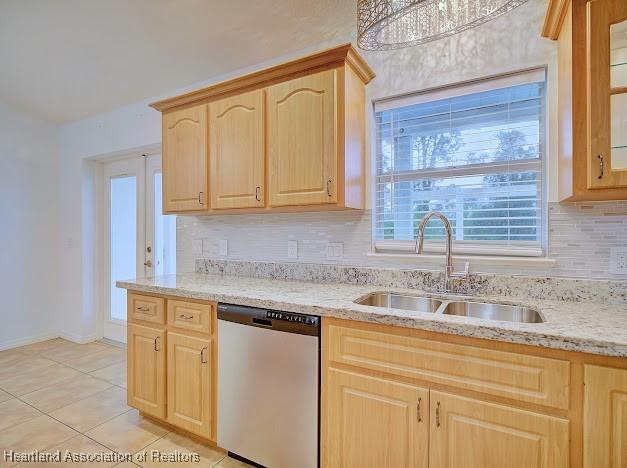 kitchen featuring light tile patterned floors, a sink, light brown cabinetry, dishwasher, and tasteful backsplash