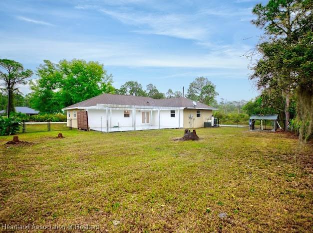 back of property with a yard and fence