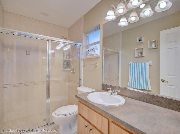 bathroom featuring a shower stall, vanity, and toilet