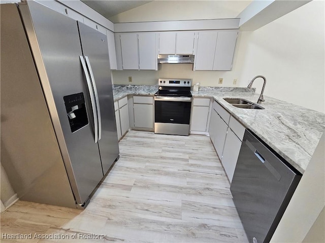 kitchen with light stone countertops, sink, kitchen peninsula, light hardwood / wood-style floors, and appliances with stainless steel finishes