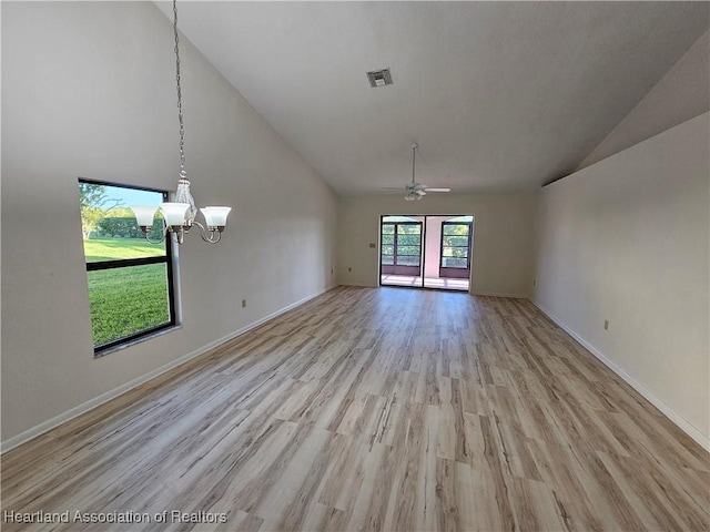 unfurnished living room with high vaulted ceiling, ceiling fan with notable chandelier, and light wood-type flooring