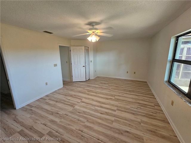 unfurnished bedroom with ceiling fan, light hardwood / wood-style floors, and a textured ceiling