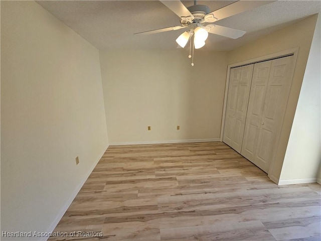 unfurnished bedroom with ceiling fan, light hardwood / wood-style floors, and a closet