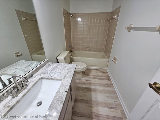 full bathroom featuring hardwood / wood-style flooring, toilet, vanity, and tiled shower / bath