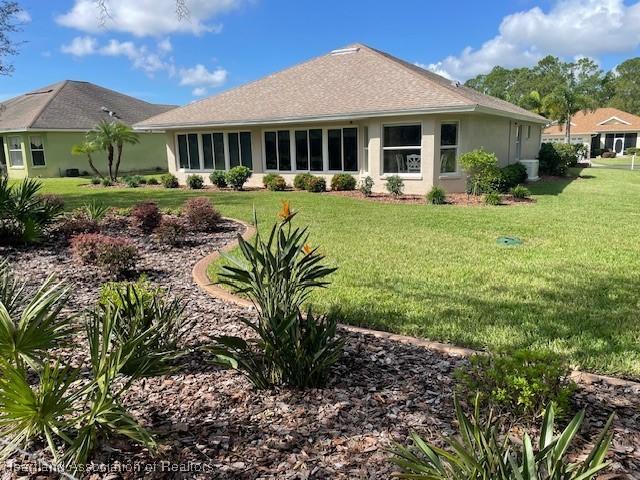 3929 Puma Dr, Avon Park, FL 33825 - rear view of house featuring a lawn and stucco siding