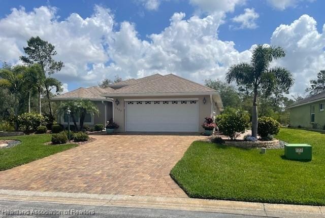 3929 Puma Dr, Avon Park, FL 33825 - ranch-style house featuring decorative driveway, an attached garage, a front yard, and stucco siding