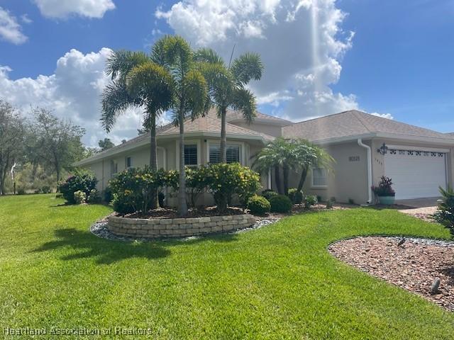 3929 Puma Dr, Avon Park, FL 33825 - single story home with a front lawn, an attached garage, stucco siding, and concrete driveway