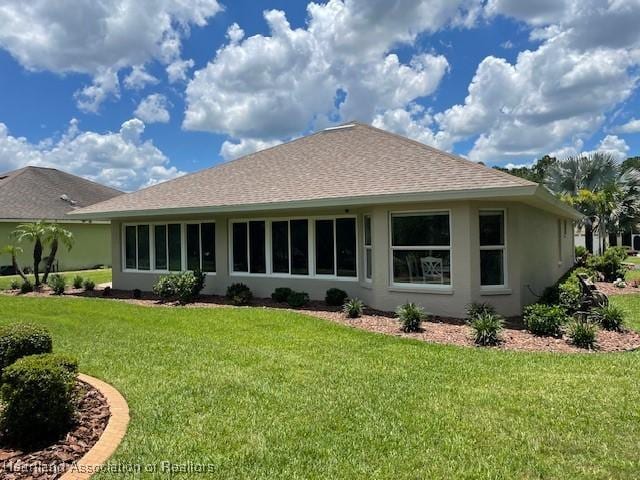 3929 Puma Dr, Avon Park, FL 33825 - back of house with a lawn, stucco siding, and roof with shingles