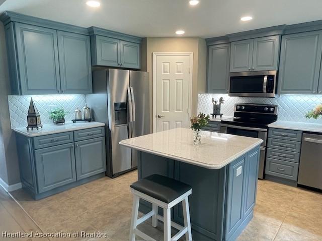 3929 Puma Dr, Avon Park, FL 33825 - kitchen with stainless steel appliances, a kitchen island, backsplash, a kitchen breakfast bar, and recessed lighting