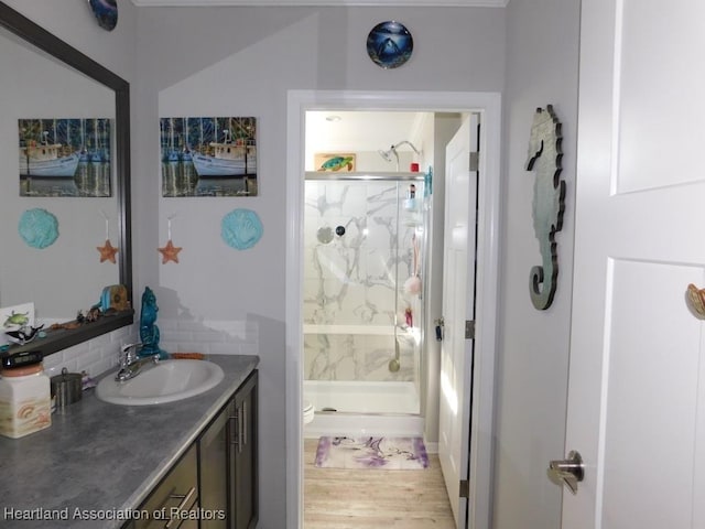 bathroom featuring walk in shower, toilet, tasteful backsplash, vanity, and hardwood / wood-style flooring