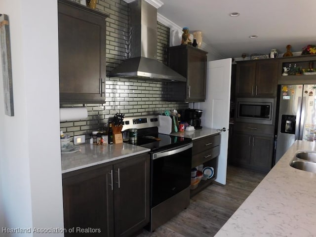 kitchen with dark brown cabinetry, wall chimney exhaust hood, and appliances with stainless steel finishes