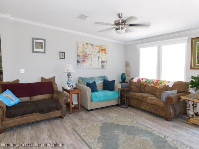 living room featuring crown molding and light hardwood / wood-style flooring