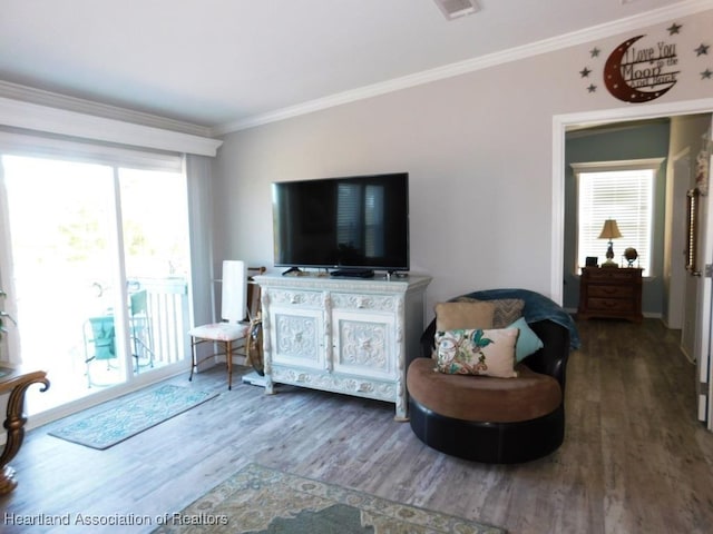 living room featuring crown molding, plenty of natural light, and dark hardwood / wood-style floors