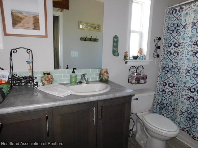 bathroom featuring vanity, decorative backsplash, toilet, and a shower with shower curtain