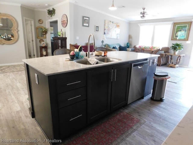 kitchen with sink, crown molding, stainless steel dishwasher, and a center island with sink