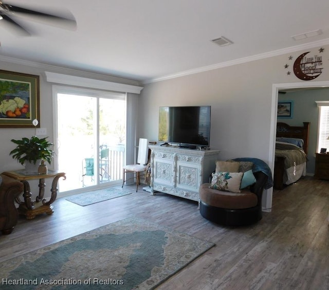 living room with crown molding, ceiling fan, and hardwood / wood-style flooring