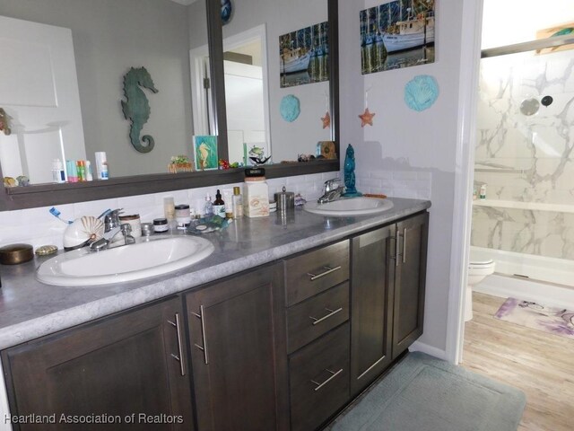 bathroom with vanity, hardwood / wood-style flooring, toilet, and walk in shower