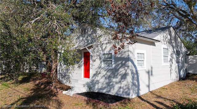 view of home's exterior with metal roof and fence