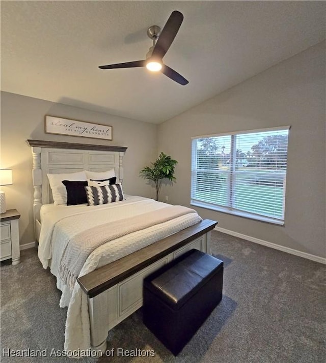 bedroom with ceiling fan, dark carpet, and vaulted ceiling