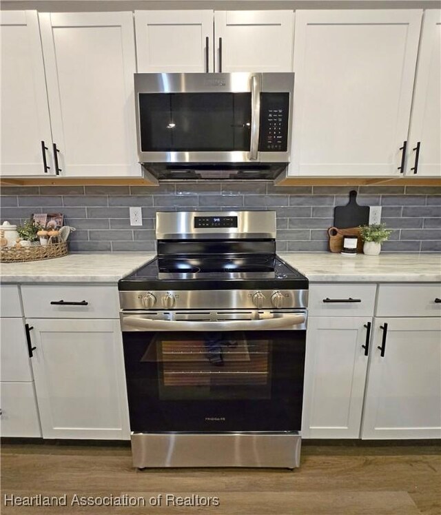 kitchen featuring white cabinetry, backsplash, and appliances with stainless steel finishes