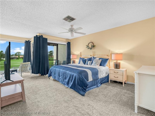 carpeted bedroom featuring a textured ceiling, a ceiling fan, visible vents, and access to exterior