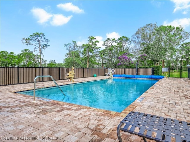 community pool featuring fence and a patio