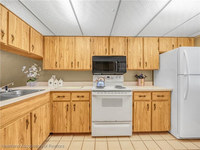 kitchen with white appliances, light tile patterned floors, light countertops, and a sink