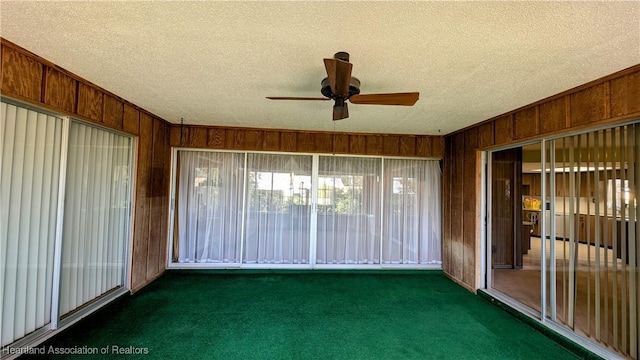 unfurnished sunroom with ceiling fan