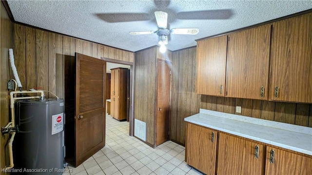 kitchen featuring ceiling fan, wood walls, electric water heater, and a textured ceiling