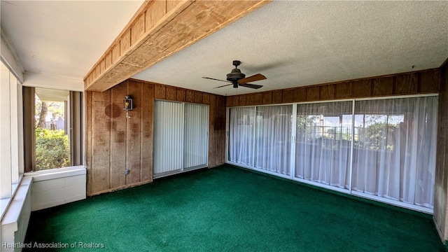 unfurnished sunroom featuring ceiling fan