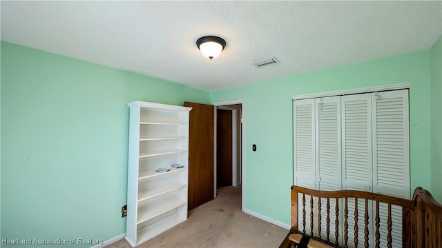 carpeted bedroom with a textured ceiling and a closet