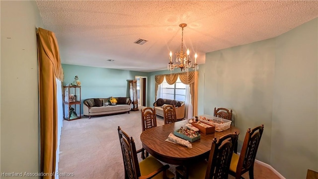 dining space featuring light carpet, a textured ceiling, and an inviting chandelier