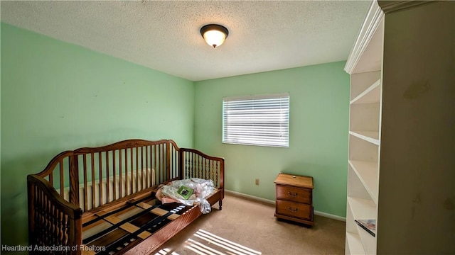 bedroom with a textured ceiling, light carpet, and a nursery area