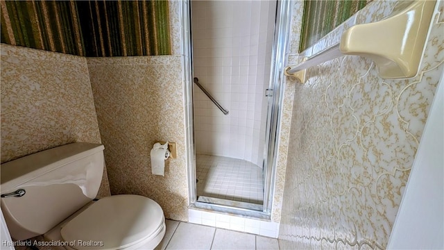 bathroom with tile patterned floors, a shower with door, and toilet