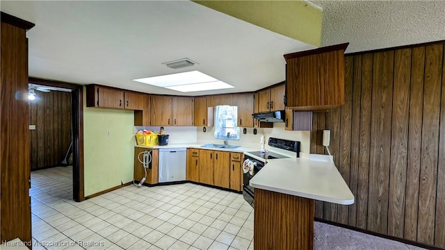 kitchen with dishwasher, black electric range oven, sink, wooden walls, and kitchen peninsula