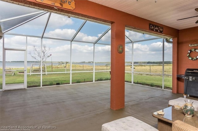 unfurnished sunroom with a rural view and ceiling fan