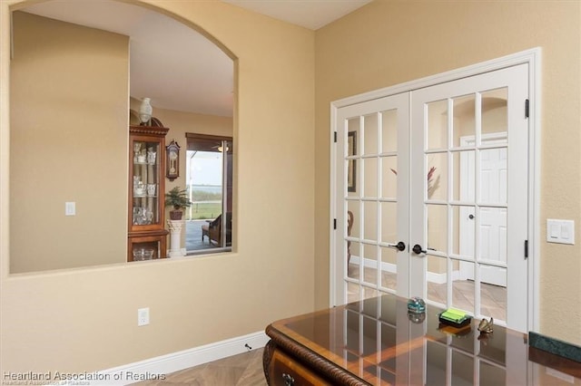 office area with arched walkways, french doors, and baseboards