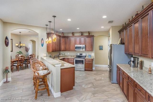 kitchen with visible vents, stainless steel appliances, arched walkways, a peninsula, and light stone countertops