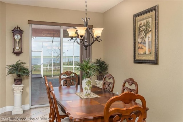 dining space featuring a notable chandelier, baseboards, and light tile patterned floors