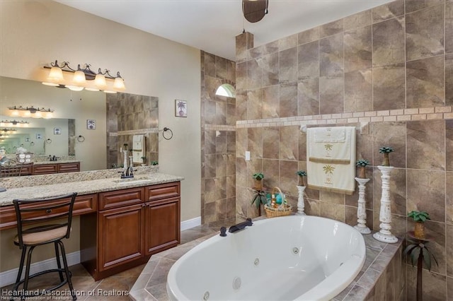 bathroom featuring tile patterned flooring, vanity, baseboards, and a whirlpool tub