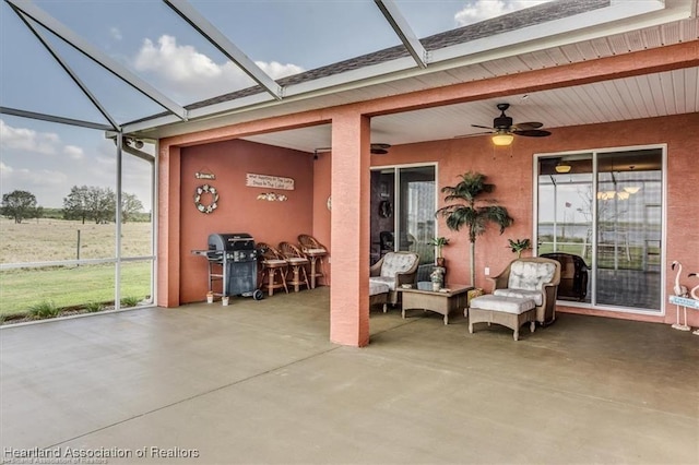 exterior space featuring area for grilling, glass enclosure, and ceiling fan