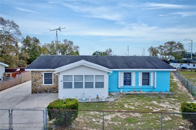 single story home with stone siding, a fenced front yard, and roof with shingles