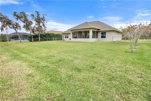 back of property featuring a fenced backyard, a shingled roof, a lawn, and stucco siding