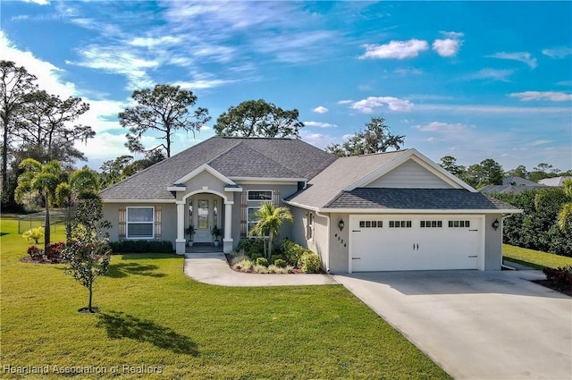 craftsman-style house with an attached garage, a front lawn, and concrete driveway