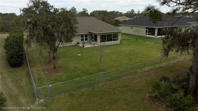 back of property featuring a lawn, a fenced backyard, a sunroom, and stucco siding