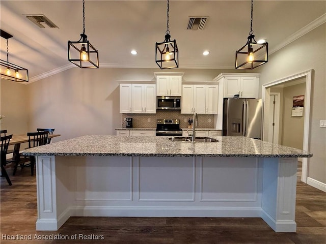 kitchen with appliances with stainless steel finishes, white cabinetry, hanging light fixtures, and visible vents