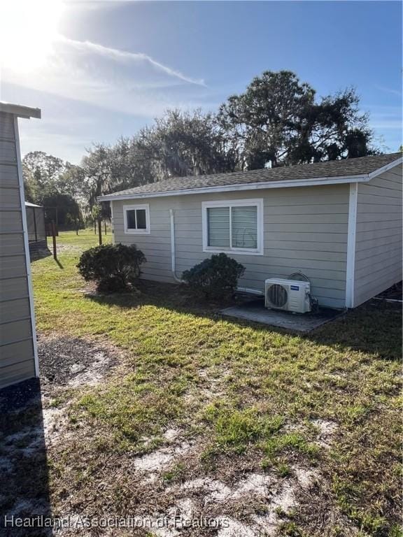 view of side of property with ac unit and a yard