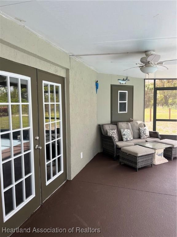 sunroom / solarium featuring a ceiling fan and french doors